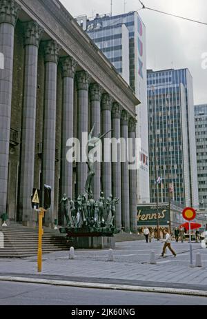 Una vista sul Konserthuset (Consert House) nel quartiere centrale di Norrmalm, Stoccolma, Svezia nel 1970. La scultura è il Gruppo Orfeo, di Carl Milles. Sullo sfondo si trovano gli edifici Hötorget, cinque alti edifici modernisti. Il blocco più vicino porta un logo pubblicitario gigante per le TV e le radio Dux. Norrmalm si trova nel centro di Stoccolma. Questa immagine proviene da una trasparenza a colori 35mm amatoriale – una fotografia vintage 1970s. Foto Stock