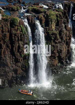 Barca turistica che esplora le cascate di Iguazu al confine tra Argentina e Brasile. Foto Stock