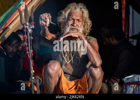 L'uomo santo indiano Amar Bharati Urdhavaahu, che ha tenuto il suo braccio sollevato per oltre 40 anni in onore del Dio indù Shiva, al Festival Kumbh Mela in India. Foto Stock