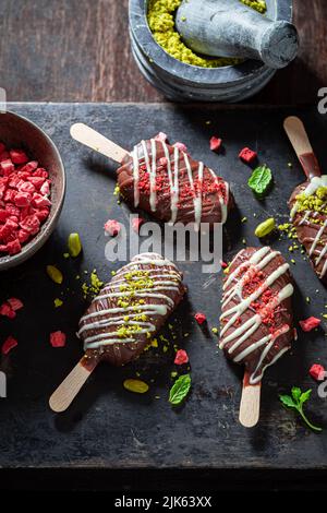 Deliziosi e fatti in casa, con fragole e pistacchi. Possicicles come un piccolo spuntino perfetto. Foto Stock