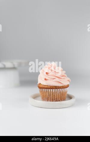 Cupcake alla vaniglia con glassa rosa, cupcake semplice con crema di burro rosa pastello Foto Stock