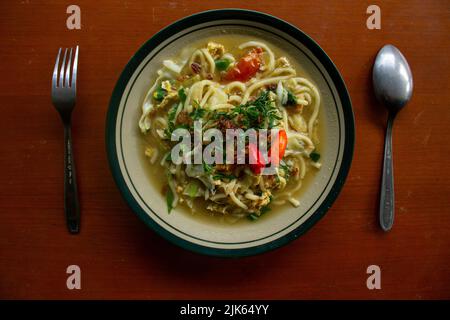 Mie godog Jawa o bakmi jawa o java noodle o Mie rebus o spaghetti bolliti con cucchiaio e forchetta. Tagliatelle tradizionali indonesiane di cibo di strada da java, Foto Stock