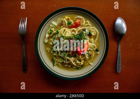 Mie godog Jawa o bakmi jawa o java noodle o Mie rebus o spaghetti bolliti con cucchiaio e forchetta. Tagliatelle tradizionali indonesiane di cibo di strada da java, Foto Stock