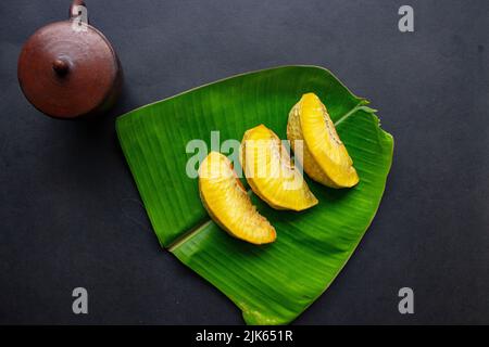 goreng sukun o pane fritto servito a foglia di banana su sfondo nero Foto Stock