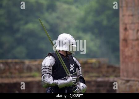 Cavaliere in un'armatura luminosa. Dettagli caschi in metallo. Guerriero medievale con spada Foto Stock