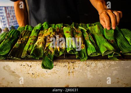 otak - otak è un alimento a base di pesce sgombro tritato avvolto in foglie di banana, cotto e servito con salsa piccante e aspro. otak-otak è tradizione Foto Stock