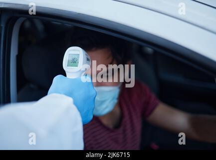 La tua temperatura sembra essere buona, un uomo che prende la sua temperatura. Foto Stock