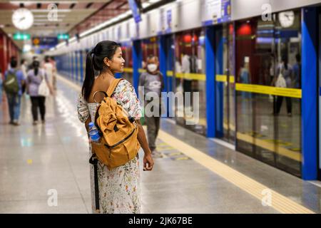 Bangkok Thailandia, Ritratto di bella donna asiatica turista in attesa di Skytrain alla piattaforma della stazione ferroviaria in città. Le donne fidate godono di vita cittadina viaggi e shopping Foto Stock