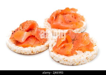 Gustosi sandwich di torta al riso con fette di salmone fresco isolate su bianco. Facile colazione e cibo dietetico. Pane croccante con pesce rosso. Spuntini dietetici sani - isolamento Foto Stock