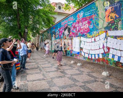 Praga, Repubblica Ceca - Giugno 2022: Turisti che guardano e scattano foto al Muro di Lennon a Praga. Foto Stock
