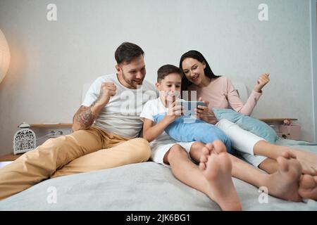 Papà, mamma e figlio cordiali trascorrono del tempo insieme Foto Stock