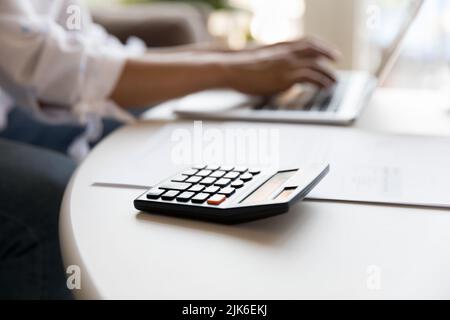 Calcolatrice e documenti cartacei sul tavolo del proprietario di abitazione, freelance Foto Stock