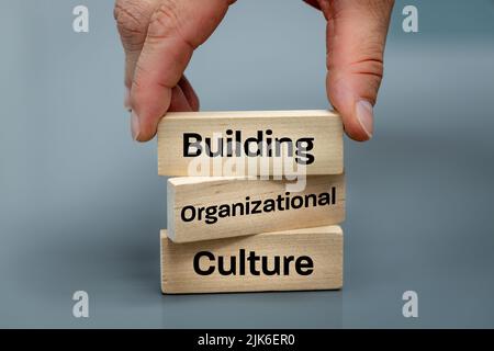 Un blocco di legno con le parole Building, Organizational, Culture, Modern Approach to Working with people in a team, Creative Concept Foto Stock