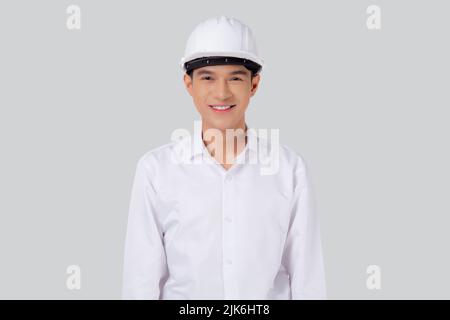 Ritratto giovane asiatico uomo è ingegnere indossare casco in piedi e sorridente con sicuro isolato su sfondo bianco, bello maschio è architetto o co Foto Stock