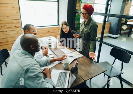 Team di imprenditori multiculturali che hanno una discussione durante una riunione di consiglio. Gruppo di professionisti aziendali diversi che condividono idee creative Foto Stock