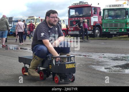 Blookburgh, Cumbria, Regno Unito. Luglio 31st 2022. Un uomo guida un mini veicolo a vapore Tarmac lungo la pista al Cumbria Steam Gathering presso il campo aereo di Flookburgh nella Cumbria meridionale. Molti vecchi grandi e piccoli motori a vapore insieme ad alcuni altri veicoli d'epoca. PIC by Credit: Michael Scott/Alamy Live News Foto Stock