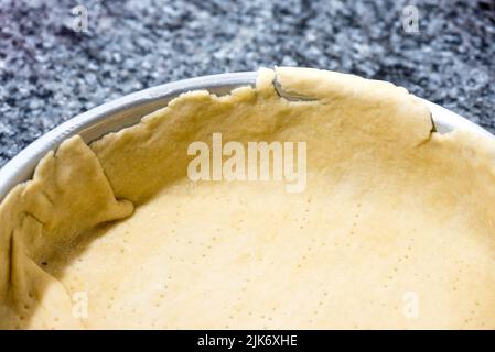 Dettagli su una pasta pre-cotta prima di riempirla con salsa di cipolla per cucinare una torta. Foto Stock