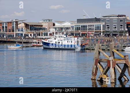 Baia di Cardiff con barca Sea Cadets ormeggiata a un pontile. Un'antica struttura di ormeggio in legno chiamata delfino in primo piano. Data di agosto 2022. Estate Foto Stock