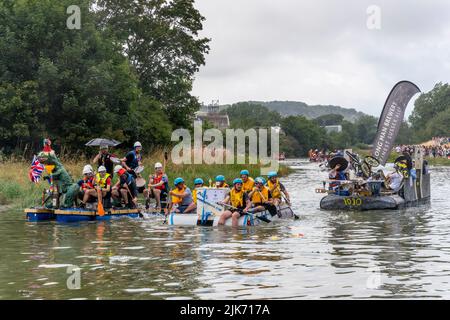 Lewes, Regno Unito. 31st luglio 2022. La gente del posto in zattere fatte in casa partecipa alla corsa di Lewes Raft sul fiume Ouse da Lewes a Newhaven. La Raft Race è un evento annuale organizzato da Lewes Round Table in aiuto di enti di beneficenza locali. Tradizionalmente, gli spettatori si allineano sulla riva del fiume e gettano uova e farina alle zattere con la gente sulle zattere proteggendosi con scudi fatti in casa. Credit: Grant Rooney/Alamy Live News Foto Stock