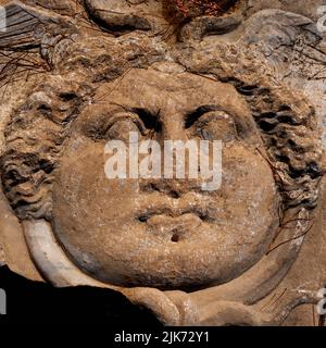 Maschera alata di Gorgone o Medusa, un tempo ritenuta per scongiurare il male, su un sarcofago romano in pietra nella necropoli di Manastirina, fuori le mura dell'antica città greca e romana di Salona, a Solin vicino a Spalato in Dalmazia, Croazia. Salona, con una popolazione di circa 60 000 abitanti, era una volta la capitale della provincia romana della Dalmazia. Dettaglio quadrato. Foto Stock