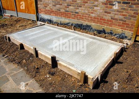 Base in calcestruzzo per capannone nuovo con casseforme in posizione mostrando centro rigato e bordo liscio Foto Stock