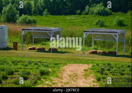 Arbors in legno dipinto con sedie e fieno per rilassarsi con ombra di legno in natura Foto Stock