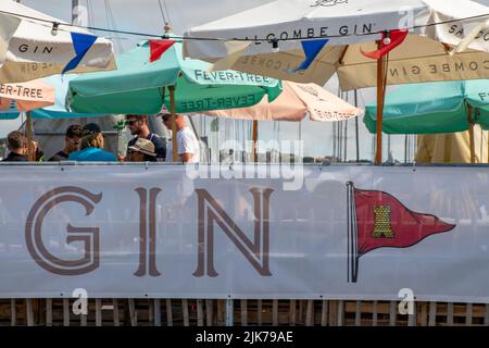 i membri dell'isola di wight island sailing club bevono su un balcone sotto gli ombrelloni durante la regata annuale della settimana di cowes sull'isola di wight uk Foto Stock