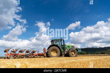 Aratura in stoppie su un campo arabile con un trattore John Deere 6155M e un aratro reversibile a 5 solchi. North Yorkshire, Regno Unito. Foto Stock