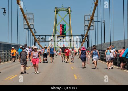 Halifax, Canada. Luglio 31st, 2022. In un bel pomeriggio soleggiato centinaia di persone si mettono a prendere le scarpe da passeggio per ammirare l'Angus MacDonald Memorial Bridge durante l'annuale Bridge Walk. Il ponte MacDonald che collega Halifax a Dartmouth oggi è gratuito per consentire ai pedoni di godere della vista del porto e camminare da un lato all'altro. Credit: Meanderingemu/Alamy Live News Foto Stock