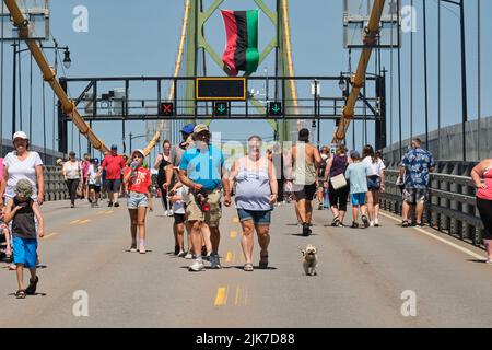 Halifax, Canada. Luglio 31st, 2022. In un bel pomeriggio soleggiato centinaia di persone si mettono a prendere le scarpe da passeggio per ammirare l'Angus MacDonald Memorial Bridge durante l'annuale Bridge Walk. Il ponte MacDonald che collega Halifax a Dartmouth oggi è gratuito per consentire ai pedoni di godere della vista del porto e camminare da un lato all'altro. Credit: Meanderingemu/Alamy Live News Foto Stock