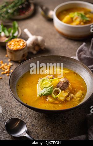 Primo piano di una ciotola di zuppa di piselli con pezzi di prosciutto e carne Foto Stock