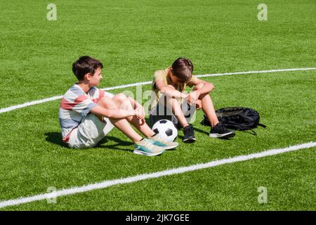 Ragazzo adolescente confortante consolante infastuito triste amico nello stadio della scuola. Educazione, bullismo, conflitto, relazioni sociali, problemi a scuola, apprendimento Foto Stock