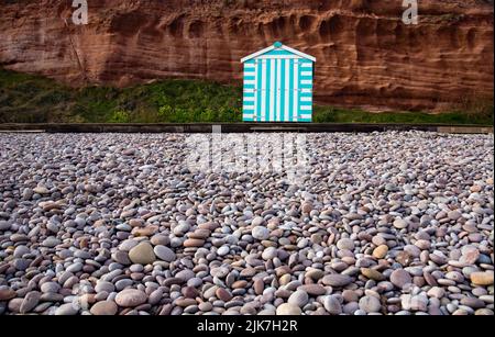 Una singola capanna da spiaggia solita sul singolo di una spiaggia di Devon Foto Stock