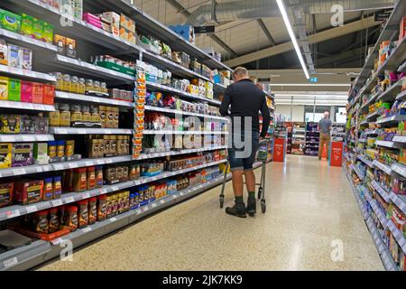Vista posteriore Vista posteriore persona che fa shopping nel supermercato Co Op che guarda gli scaffali del caffè e del tè costo della vita Gran Bretagna Regno Unito luglio 2022 KATHY DEWITT Foto Stock