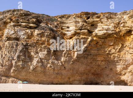 Sagres, Portogallo. 22nd luglio 2022. Gli ombrelloni si trovano di fronte ad una parete rocciosa presso la spiaggia 'Praia do Beliche'. Credit: Viola Lopes/dpa/Alamy Live News Foto Stock