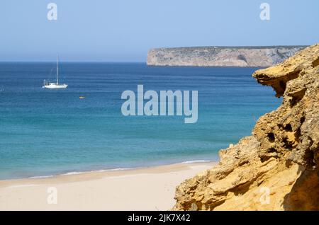 Sagres, Portogallo. 22nd luglio 2022. Una barca a vela si aggira in una baia di fronte alla spiaggia 'Praia do Beliche'. Credit: Viola Lopes/dpa/Alamy Live News Foto Stock