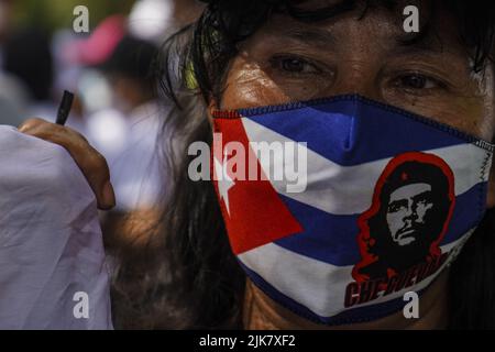 San Salvador, El Salvador. 31st luglio 2022. Un protettore che indossa una maschera facciale con una bandiera di Cuba guarda avanti durante una manifestazione che commemora il 47th anniversario di un massacro di studenti universitari da parte dei militari il 30 luglio 1975 e lo stato di emergenza in corso ordinato dal Congresso Salvadoran. (Foto di Camilo Freedman/SOPA Images/Sipa USA) Credit: Sipa USA/Alamy Live News Foto Stock