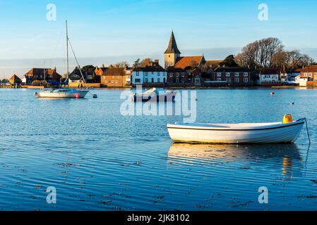 Una vista attraverso il porto verso Bosham villaggio su un congelamento assolato pomeriggio invernale, Bosham, West Sussex, in Inghilterra Foto Stock