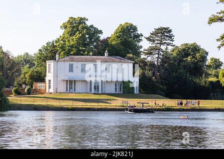 La Manor House a Shepperton, Surrey, visto dal retro, il Tamigi approccio con prato al fiume e la gente gode di tempo soleggiato Foto Stock