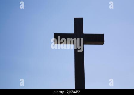 Croce con sagome sullo sfondo blu del cielo. Foto Stock