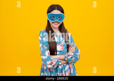 Bambina adolescente in maschera samba al carnevale isolato su sfondo giallo. Bambini in maschera di carnevale sul partito di compleanno, concetto di festa. Foto Stock