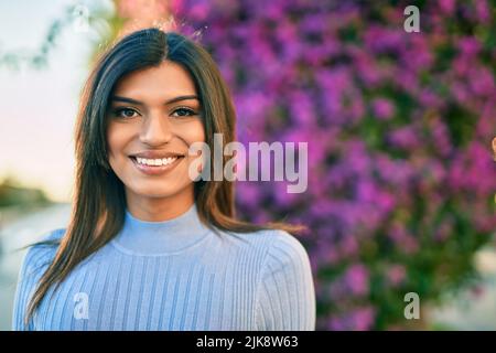 Bella donna ispanica sorridente confidente al parco Foto Stock