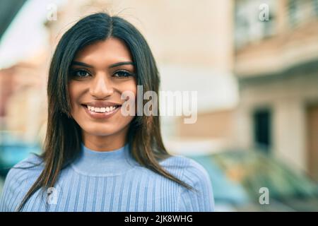 Bella donna ispanica sorridente confidente in città Foto Stock
