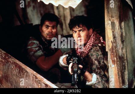 Paul Sanchez & Charlie Sheen Film: Navy Seals (USA 1990) personaggi: Ramos, Lt. Dale Hawkins regista: Lewis Teague 20 luglio 1990 **ATTENZIONE** questa foto è solo per uso editoriale ed è il copyright di MGM e/o del fotografo assegnato dalla Film o dalla Società di produzione e può essere riprodotto solo da pubblicazioni in concomitanza con la promozione del suddetto Film. È richiesto un credito obbligatorio per MGM. Il fotografo deve essere accreditato anche quando è noto. Nessun uso commerciale può essere concesso senza l'autorizzazione scritta della Film Company. Foto Stock