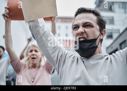 Bene, non permettere mai questo: Un giovane che marciò contro una protesta contro la vaccinazione. Foto Stock