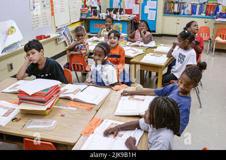 Miami Florida,Frederick Douglass Elementary School,quartiere a basso reddito,studenti ispanici ragazzi maschi,ragazze nere classe femminile tavoli da lavoro Foto Stock