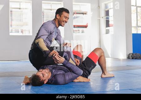 Hai capito. Sparo a tutta lunghezza di un sensei jiu jitsu che spara con uno dei suoi studenti durante una lezione. Foto Stock