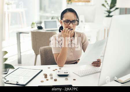 I soldi contano sempre lo sottolineano fuori: Una giovane donna d'affari che guarda fuori mentre calcola le finanze in un ufficio. Foto Stock