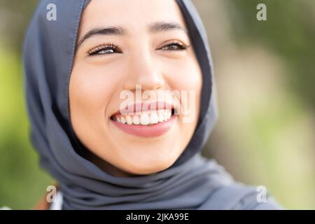 Attraente donna musulmana sorridente con un'espressione rilassata Foto Stock