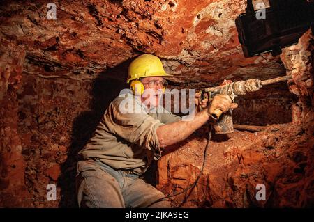 Grahame McMahon, pensionato il clergyman anglicano ora opale minatore sotterraneo nella sua miniera a Lightning Ridge Foto Stock